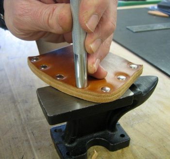 Setting rivets in leather on mini anvil